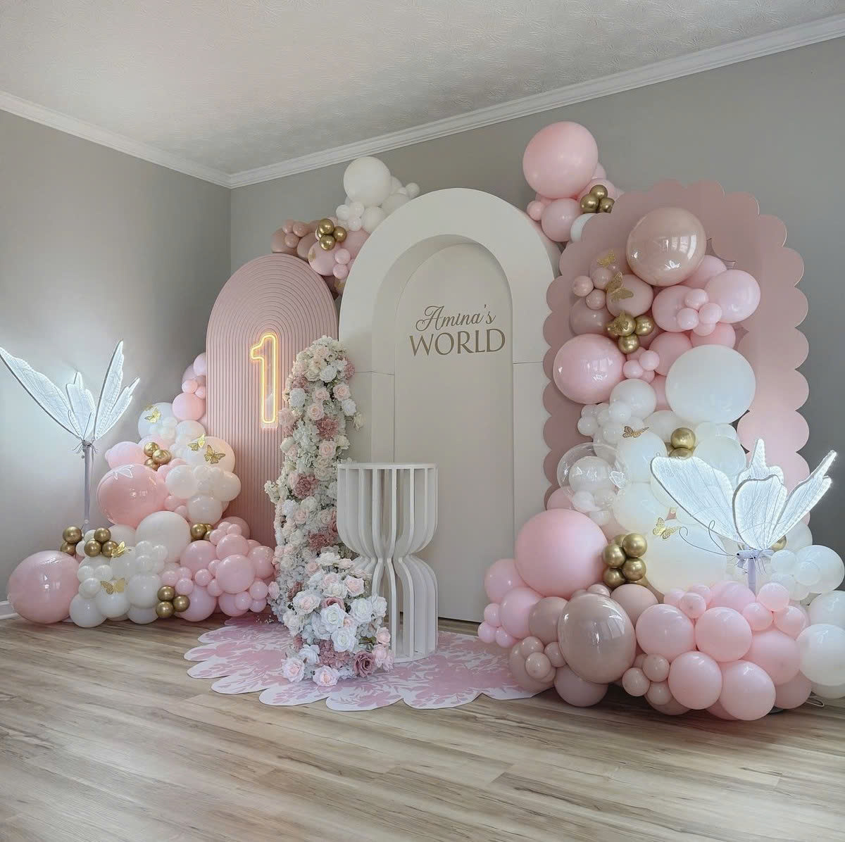 Mẫu **backdrop sinh nhật bé gái** tone hồng pastel sang trọng, kết hợp bóng bay, hoa tươi, cánh bướm và số tuổi nổi bật.