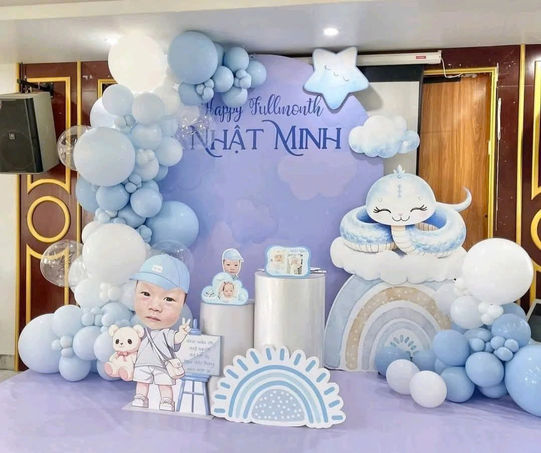 Mẫu **backdrop sinh nhật cho bé** tone xanh pastel dễ thương, kết hợp bóng bay, mây, cầu vồng và nhân vật hoạt hình đáng yêu.
